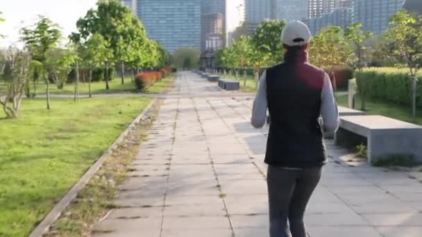 Μια Γυναίκα Τρέχει Μέσα Από Πάρκο Της Πόλης Από Πίσω — Αρχείο Βίντεο