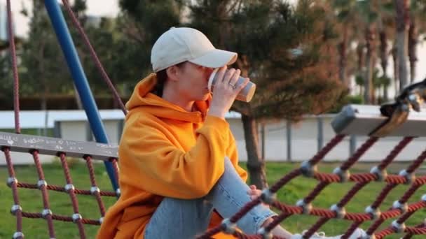 Młoda Hipsterka Siedzi Hamaku Parku Miejskim Pije Filiżanki Kawy — Wideo stockowe