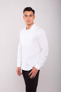 Beyaz tişört giyen şık moda bir adam, stüdyo resmi.