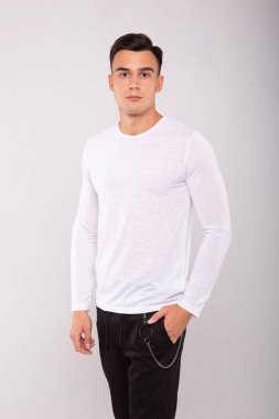 Beyaz tişört giyen şık moda bir adam, stüdyo resmi.