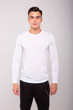 Beyaz tişört giyen şık moda bir adam, stüdyo resmi.