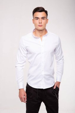Beyaz tişört giyen şık moda bir adam, stüdyo resmi.