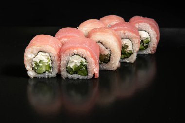 Set of Different Sushi and Rolls over Black Background