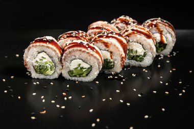 Set of Different Sushi and Rolls over Black Background