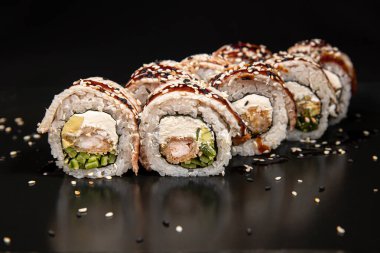 Set of Different Sushi and Rolls over Black Background