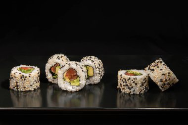 Set of Different Sushi and Rolls over Black Background