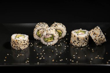 Set of Different Sushi and Rolls over Black Background