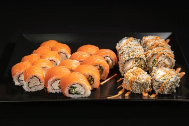 Set of Different Sushi and Rolls over Black Background