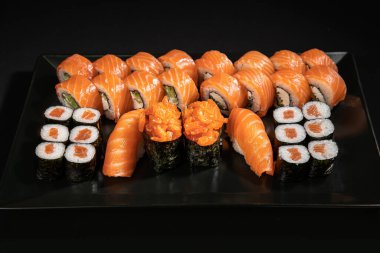 Set of Different Sushi and Rolls over Black Background
