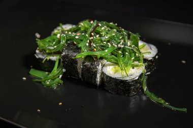 Set of Different Sushi and Rolls over Black Background