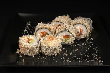 Set of Different Sushi and Rolls over Black Background
