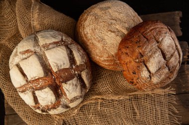 Ekmek. Ekmek ahşap arka plan üzerinde. Ahşap masa üzerinde pişmiş gıda çeşitli closeup. Yüksek çözünürlük