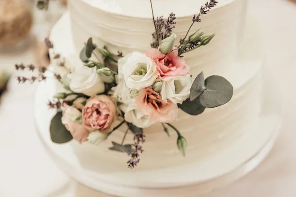 用浓密的乳白色泡沫和干枯的玫瑰做装饰的婚礼蛋糕 这幅图有很浅的深度 — 图库照片
