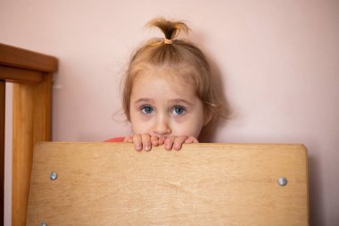 Üzgün mavi gözlü sarışın küçük bir kızın portresi.