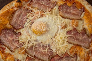 İtalyan pizzasına yakın plan jambon, yeşil zeytin ve roka.
