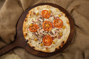 İtalyan pizzasına yakın plan jambon, yeşil zeytin ve roka.