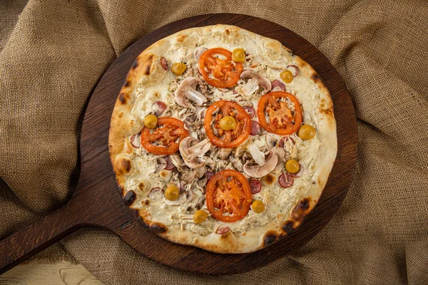 İtalyan pizzasına yakın plan jambon, yeşil zeytin ve roka.