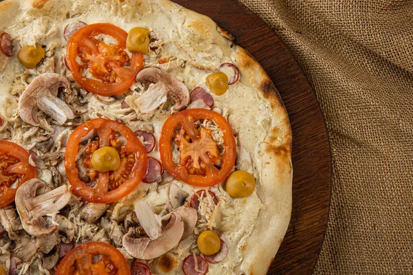 İtalyan pizzasına yakın plan jambon, yeşil zeytin ve roka.