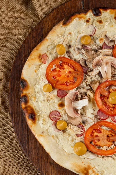 İtalyan pizzasına yakın plan jambon, yeşil zeytin ve roka.