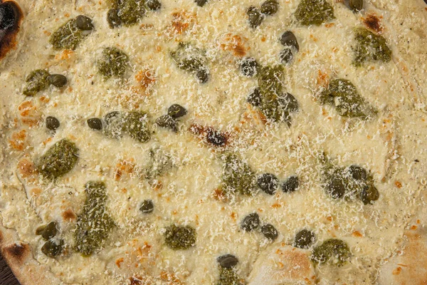 İtalyan pizzasına yakın plan jambon, yeşil zeytin ve roka.