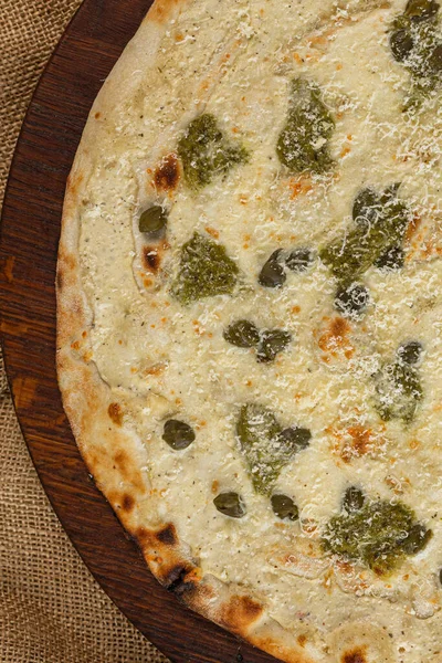 İtalyan pizzasına yakın plan jambon, yeşil zeytin ve roka.