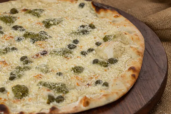 İtalyan pizzasına yakın plan jambon, yeşil zeytin ve roka.