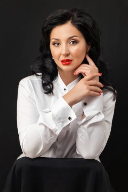 Parlak mavi makyajlı güzel bir genç kadının portresi. Dudaklarında parlak kırmızı ruj olan güzel bir esmer. Uzun siyah saçlı güzel bir kız. Esmer kadının yakın çekim yüzü..