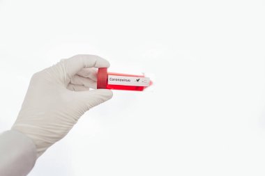 Etiketli şeffaf cam şişeler ve test COVID-19 aşısı, masanın üzerinde şırınga.