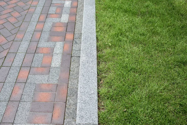 Çimen desenli taş kaldırım. Çamurlu kaldırım arka planının en üst görüntüsü. Eski kaldırım taşları sokağının soyut arkaplanı