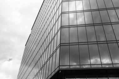 Gökyüzü arka planında cam cepheli modern ofis binası. Ofis binasının şeffaf cam duvarı.