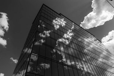 Gökyüzü arka planında cam cepheli modern ofis binası. Ofis binasının şeffaf cam duvarı.