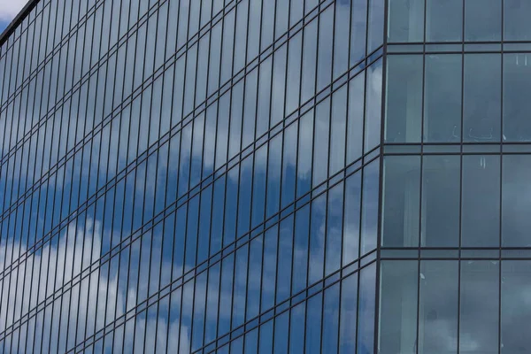 stock image Modern office building with glass facade on a clear sky background. Transparent glass wall of office building.