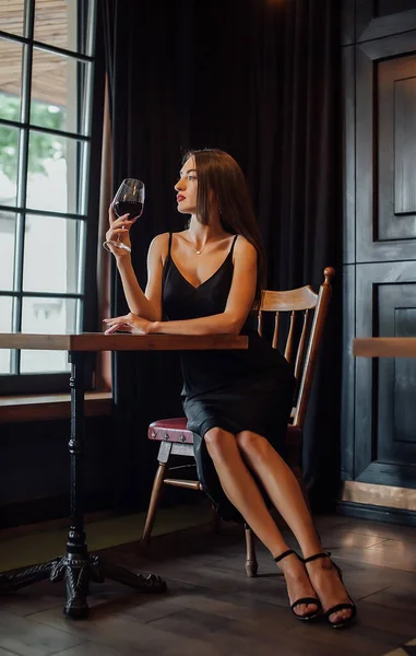 年轻的优雅女人举行杯红酒 室内拍摄 选择性焦点 — 图库照片
