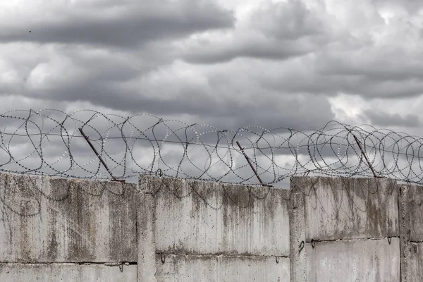 Barbed wire. Barbed wire on fence with blue sky to feel worrying.