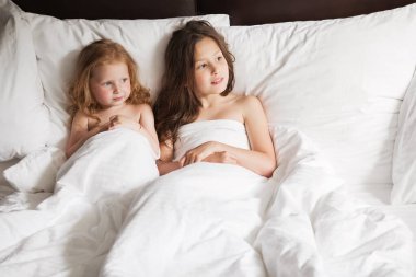 Mutlu aile evde battaniyenin altında yatıyor.