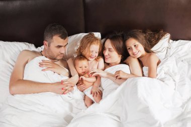 Mutlu aile evde battaniyenin altında yatıyor.