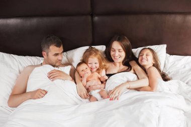 Mutlu aile evde battaniyenin altında yatıyor.
