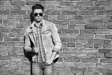 Stylish guy standing street in a denim jacket against, men's looks