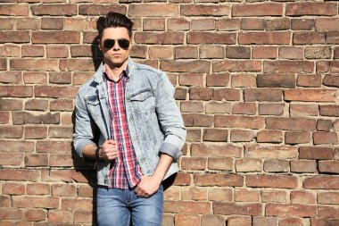 Stylish guy standing street in a denim jacket against, men's looks