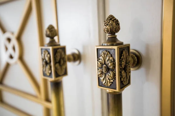 Classic vintage golden door knobs. Antique door knobs with carvings on wooden door.