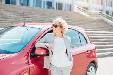 Bir araba anahtarları gösterilen çekici sarışın.