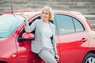 Bir araba anahtarları gösterilen çekici sarışın.