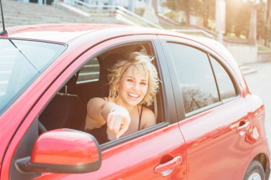 Bir araba anahtarları gösterilen çekici sarışın.