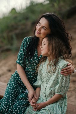 Anne ve kızının şefkatli portresi. Parkta zaman geçiriyorlar. Geçmişi bulanık. 