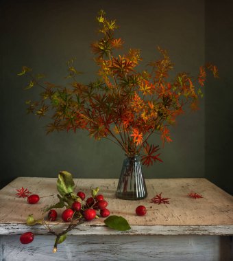 Bir buket orman menekşesi Sonbahar yaprakları ve kırmızı böğürtlenlerle.