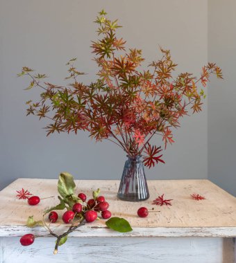 Bir buket orman menekşesi Sonbahar yaprakları ve kırmızı böğürtlenlerle.