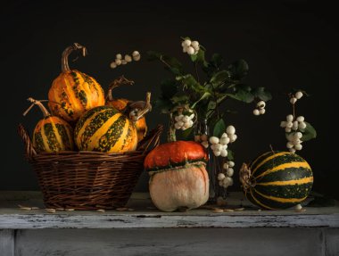 Masada olgun balkabakları var. Böğürtlenli bir buket dal. Geriye dönük natürmort.