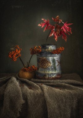 Sonbahar, akçaağaç yaprakları ve koyu arkaplanda yabanmersini ile sakin bir hayat..