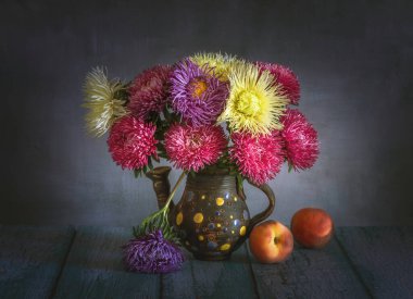 Bir buket aster ve olgun şeftaliyle durgun bir hayat