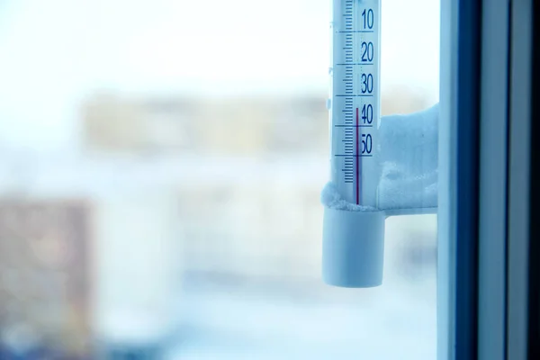 Classic mercury thermometer for measuring ambient temperature, hanging outside the window, with readings minus 30 degrees Celsius. Stock Picture